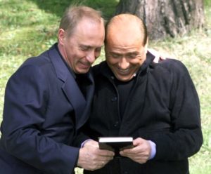 Russian President Vladimir Putin (L) presents Italian Prime Minister Silvio Berlusconi with a book printed in Russia about Berlusconi's political life, during their meeting in the presidential residence Bocharov ruchei in Russia's Black Sea resort of Sochi, April 2, 2002. Putin called Italy a privileged partner and noticed that its role in Europe is growing, Itar-Tass agency reported. (Credit : REUTERS/ITAR-TASS/KREMLIN PRESS SERVICE)